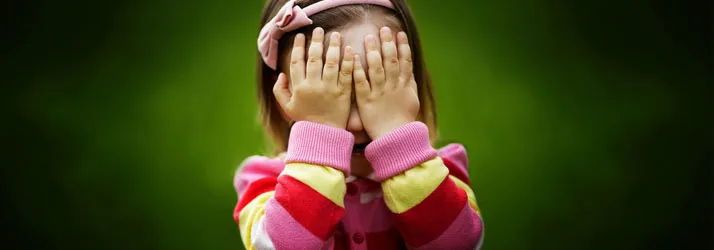 Chiropractic Fremont CA Young Girl A young girl covering her face with her hands.